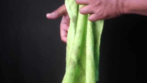 hand holding a dirty green cloth