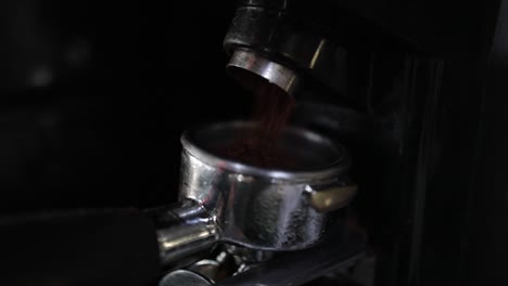 barista's point of view closeup: fresh coffee grounds being transferred to portafilter
