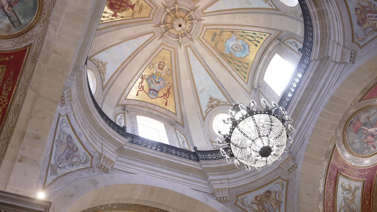elegant church dome with artwork and central hanging chandelier