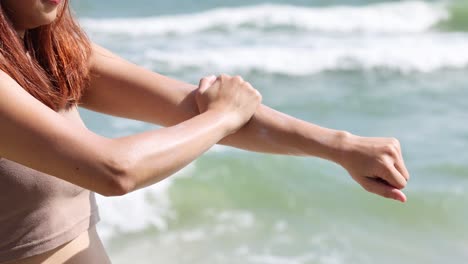 two people applying sunscreen on each other's arms.