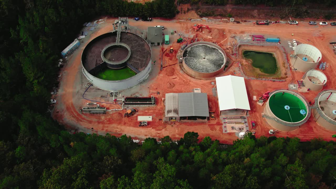 planta de tratamiento de aguas residuales en construcción rodeada de árboles en el bosque