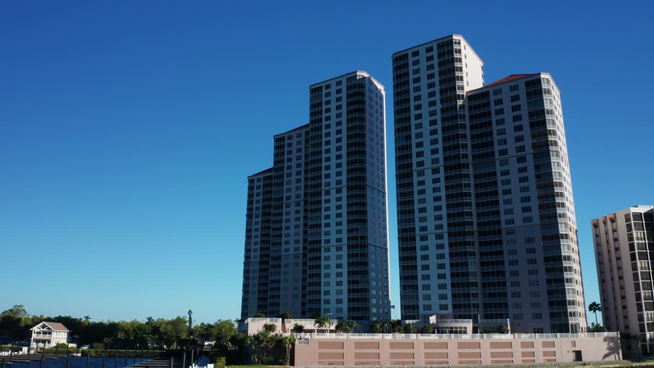 Edifícios altos e arranha-céus destacam-se proeminentemente sob um céu azul claro em Fort Myers. Ideal para promoções imobiliárias ou recursos de desenvolvimento urbano.