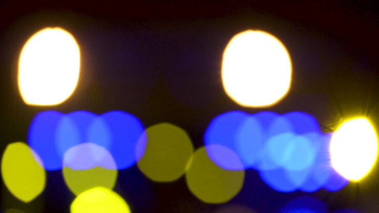 Luci gialle e blu sfocate con effetto bokeh.