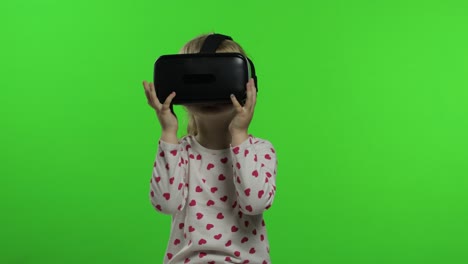 Child-girl-using-VR-headset-helmet-to-play-game.-Watching-virtual-reality-3d-360-video.-Chroma-key