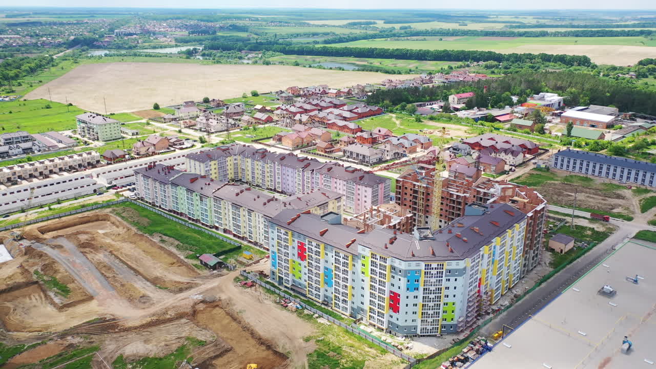 Modern residential complex in the countryside. Colorful high-rise buildings on a construction site. New microdistrict is building. Aerial view.