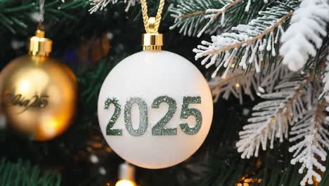 white christmas ornament with 2025 on it hanging on a christmas tree