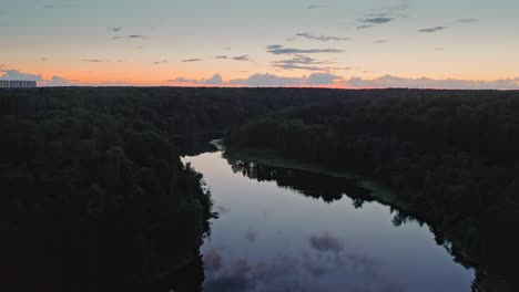 Vuelo-Sobre-La-Superficie-Del-Espejo-Del-Río-Entre-El-Bosque-Oscuro-Al-Atardecer