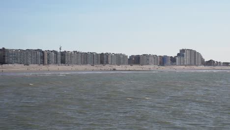 view of nieuwpoort beach from the north sea with waves heading towards shore