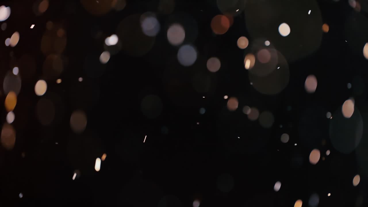 Floating abstract particle bokeh on dark background