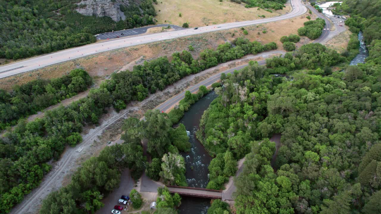 Luftoptagelse viser biler, der kører over Provo Canyon Road langs Provo River gennem bjergkæder i Utah, USA