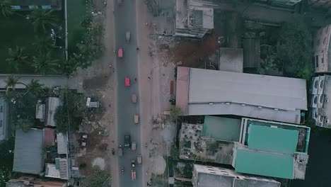 drone shot of a road from rural city vehicles are passing