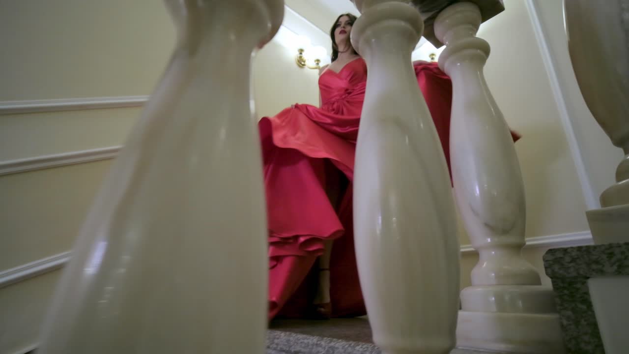 Woman in a Red Dress Walking Downstairs