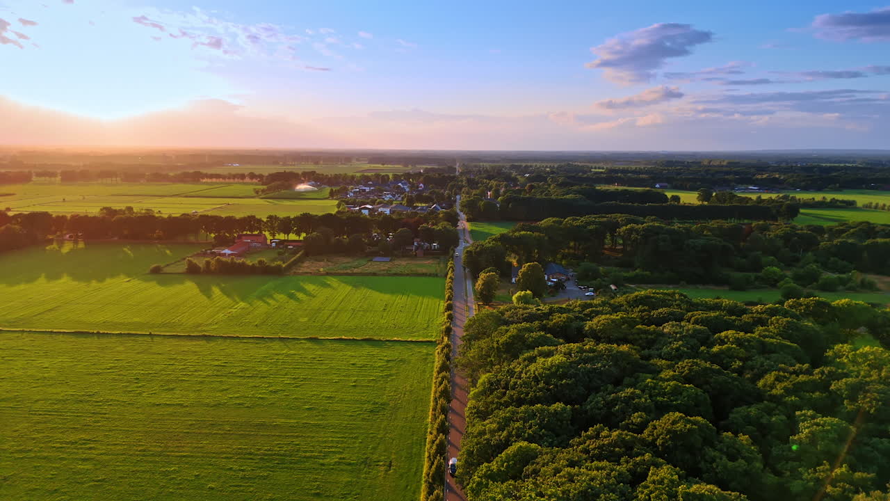Sunlit meadows and lush forests. Spectacular scenery of picturesque countryside at sunset. Aerial view