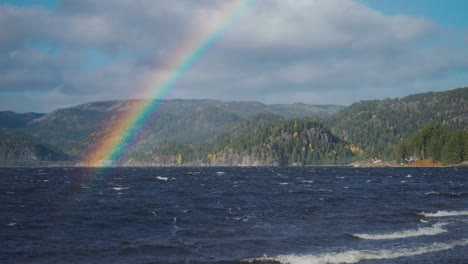 un arco iris cuelga sobre las aguas tormentosas