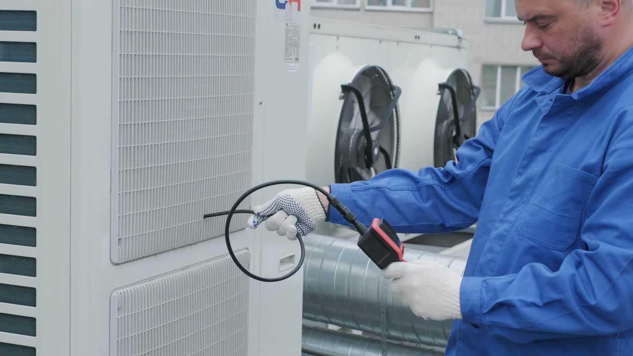 The technician uses a digital camera to check the clogging of the heat exchanger