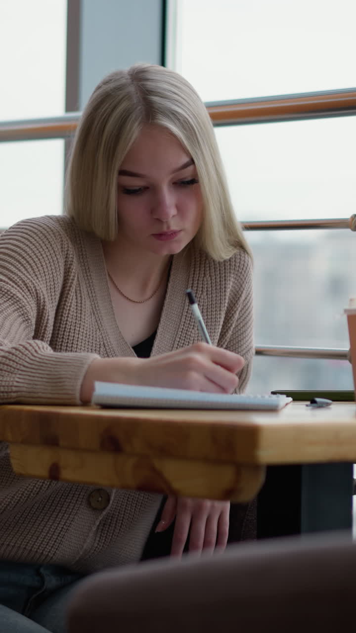 커피를 마시면서 종이에 펜을 두드리는 여성, 편안한 카페 환경에서 반영하거나 브레인 스토밍, 테이블에 커피 컵, 편안 한 분위기