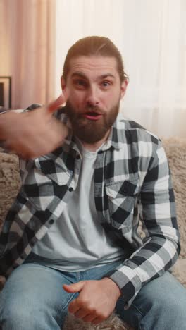 man changing like to dislike at home sofa thumbs switch ironic mood quick gesture playful twist