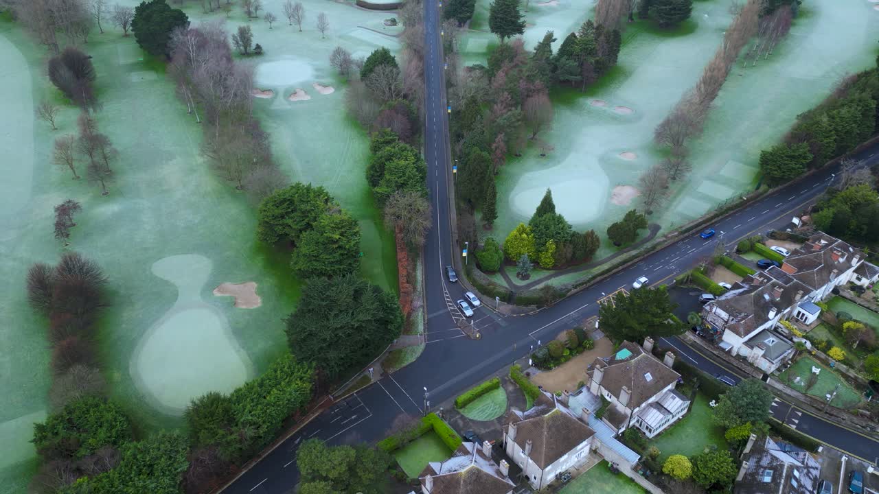 Aerial view looking down of a Junction in Churchtown Lower Road, next to Milltown Golf club - A winter afternoon with frozen grass and traffic in the road. - South Dublin, Ireland