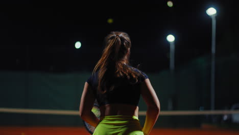 woman playing tennis at night