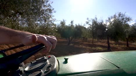 farmer hand turning the steering wheel of a tractor in the farm field