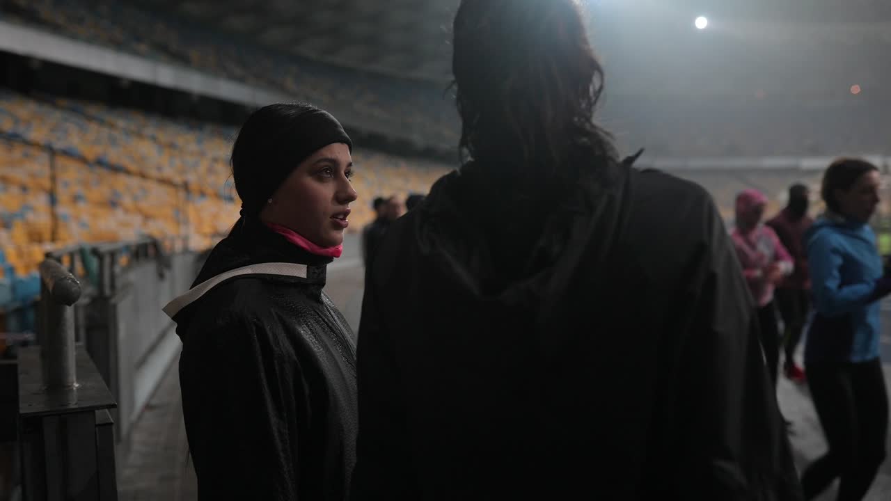 여자 축구 팀 이 경기장 에서 토론 하고 있다