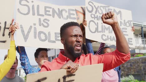 diverse group of protesters holding cardboard banners and screaming