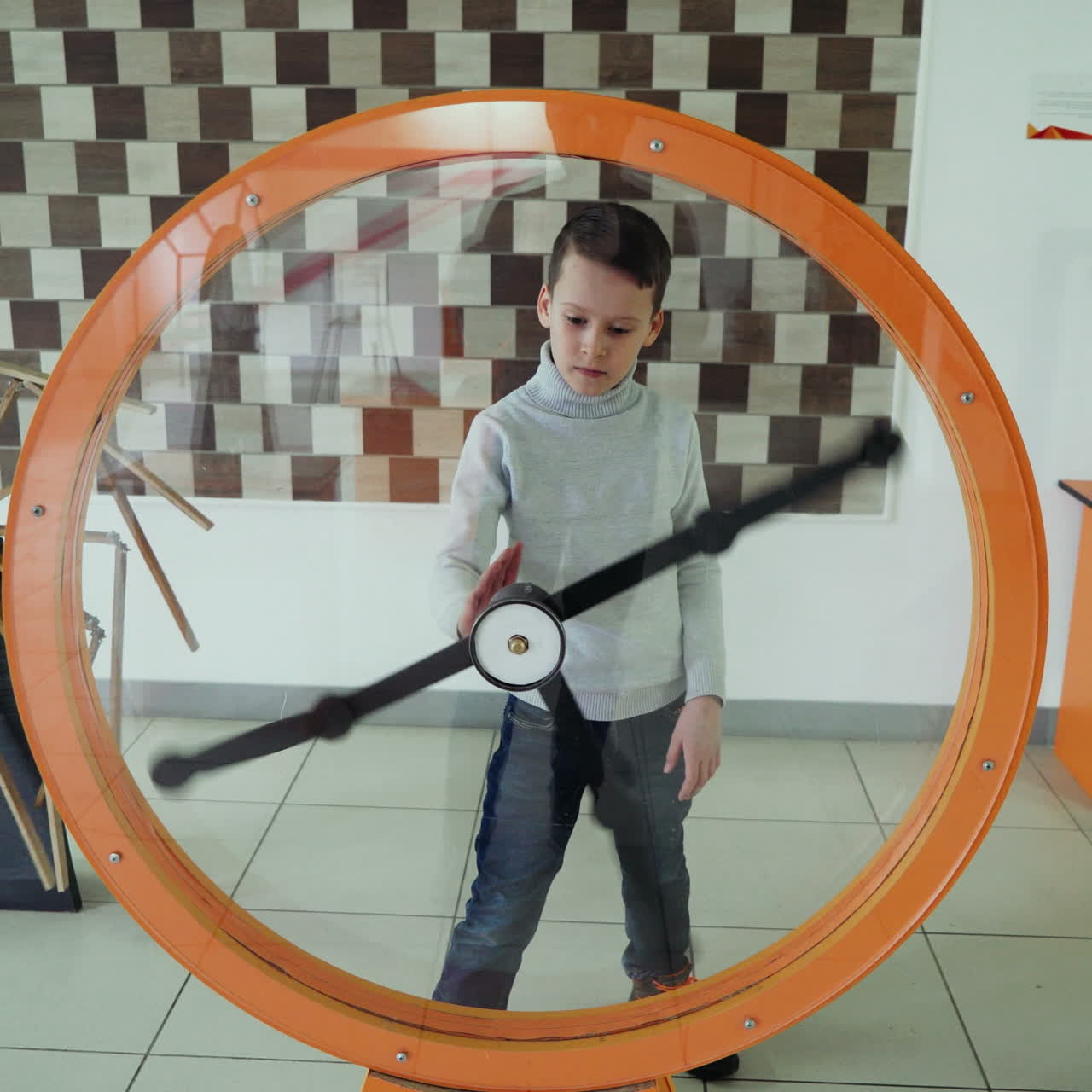 Child views the perpetual motion machine in the children's science museum. Boy in science center. Square video