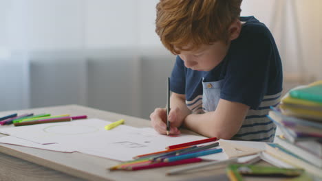 child drawing at a desk