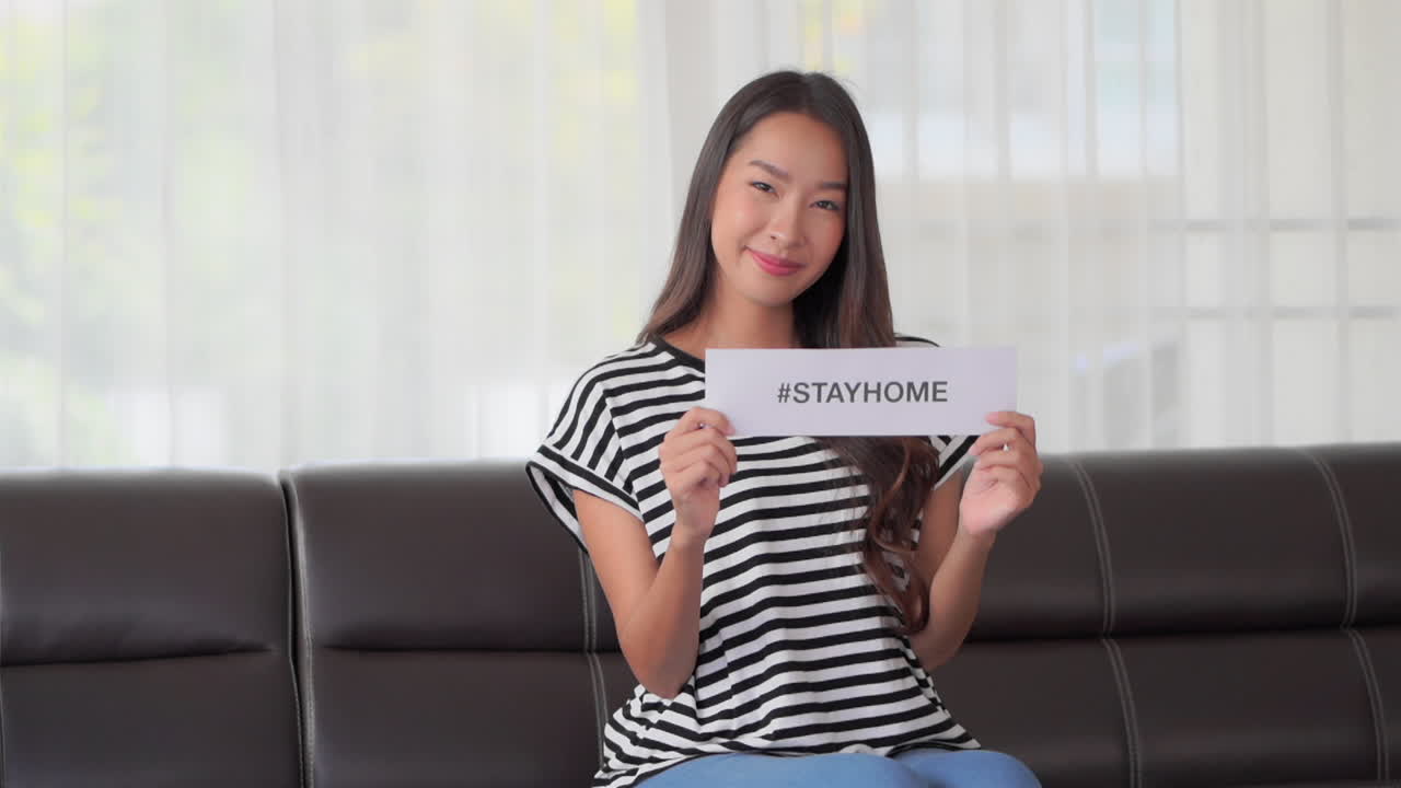 Woman with STAYHOME sign urging people to Stay Home due to Corona Crisis