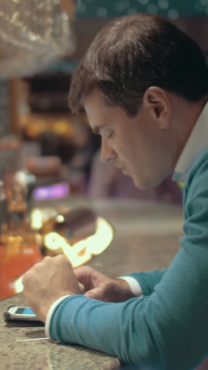 hombre usando el teléfono en el bar