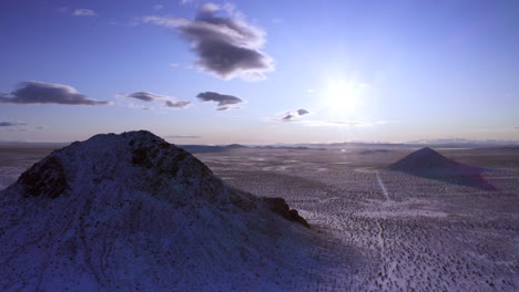 Aerial,-Sun-shining-over-frozen-Mojave-Desert-covered-in-winter-snow
