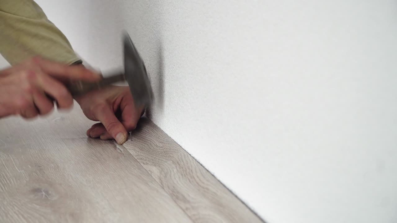 hombre usando un martillo para clavar batten laminado