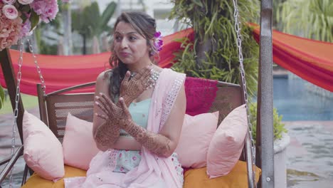 chica india atractiva mostrando su mehndi durante la boda