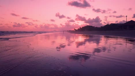 Establishing-tilting-aerial-shot-of-dramatic-sunset-with-pink-sky-and-ocean