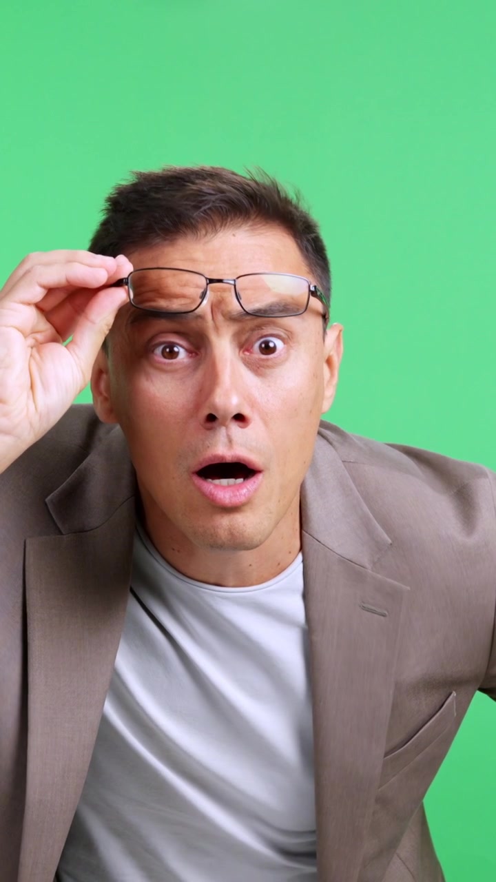 Surprised businessman taking off his glasses