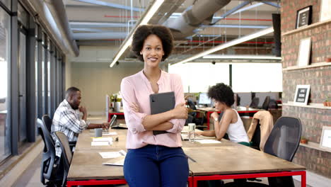 african american woman holding tablet standing confidently in modern office