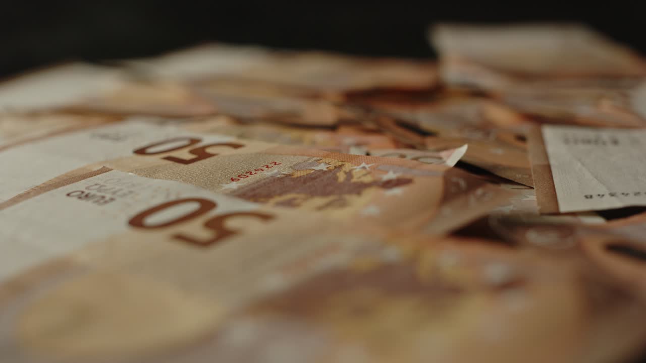 concepto de economía: hermosa muñeca de una gran cantidad de dinero en efectivo en una superficie negra