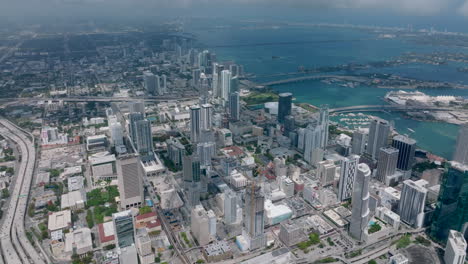 High-rise-buildings-and-traffic-infrastructure-in-metropolis.-Aerial-panoramic-footage-of-large-city-on-waterfront.-Miami,-USA