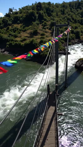 colorful suspension bridge over a waterfall