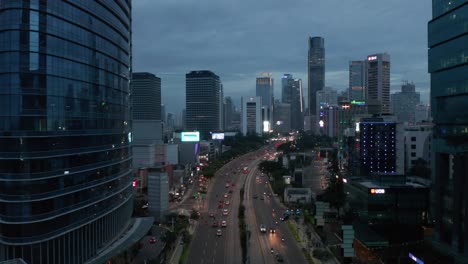 aerial pedestal descending shot of night traffic on a multi lane road through jakarta city center