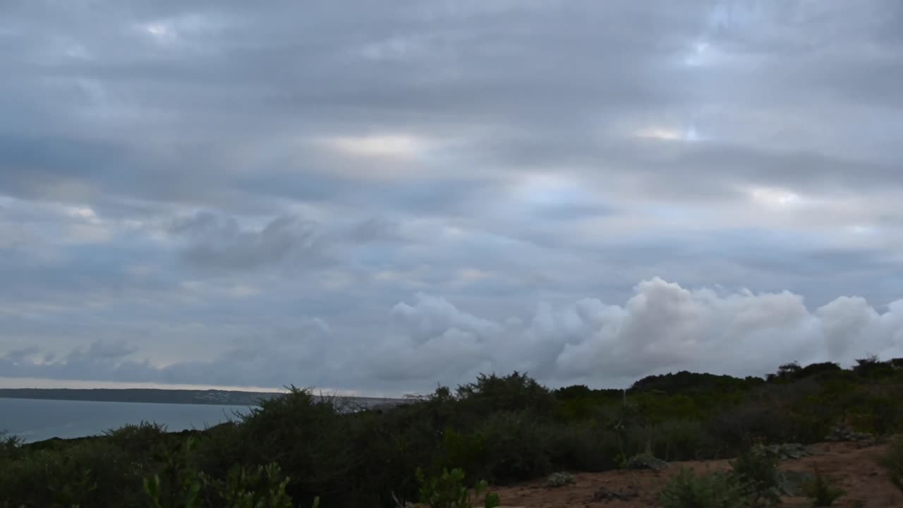 남아프리카 공화국의 모셀베이에서 해가 지는 동안 다른 방향으로 움직이는 구름의 시간 경과.
