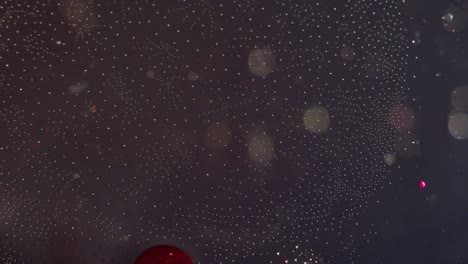 orbes rojos y claros abstractos que se mueven juntos en un fondo de textura de bokeh líquido claro