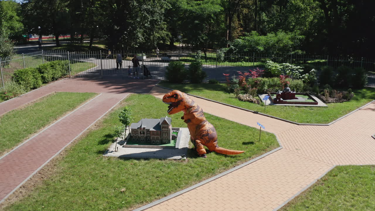 Dinosaur Costume in a Park with Miniature Houses