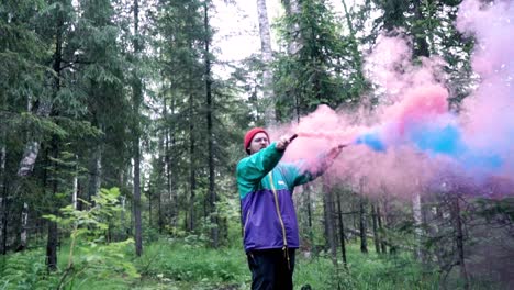 el hombre libera humo de colores en el bosque.