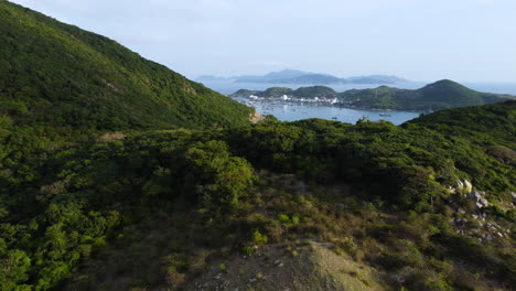 aerial revealing shot showing binh hung island behind green mountains in vietnam