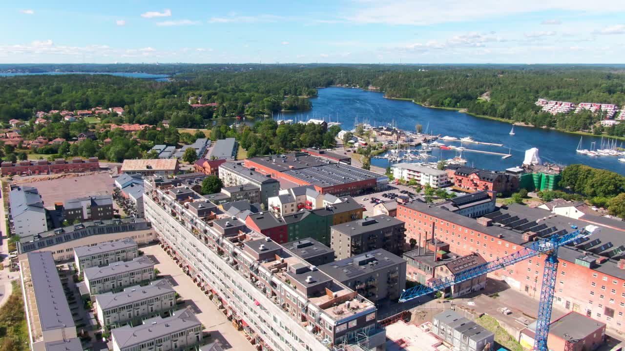 Aerial of Gustavsberg harbor showing red brick industrial heritage transformed into modern housing