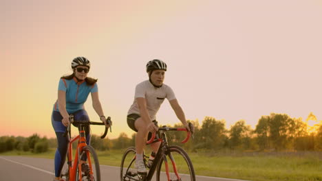 Two-cyclists-ride-together-in-mountains.-Softly-focused-hand-held-shot-of-two-professional-cyclists-from-sport-team-having-fun-during-hard-training-sprinting