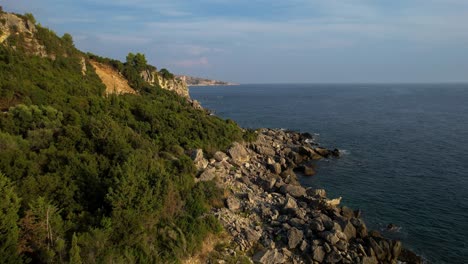 rocks on the shore of a beautiful mediterranean seaside, washed by azure sea near lagoon, motorboat leisure