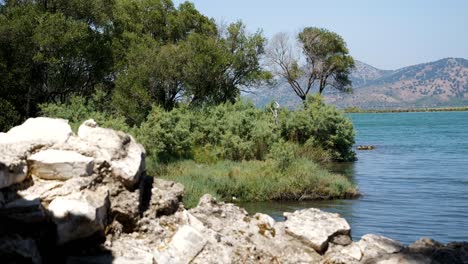 Butrint,-Albania,-Vista-De-La-Orilla-Del-Lago,-Ruinas-Antiguas-Y-Montañas-Al-Fondo