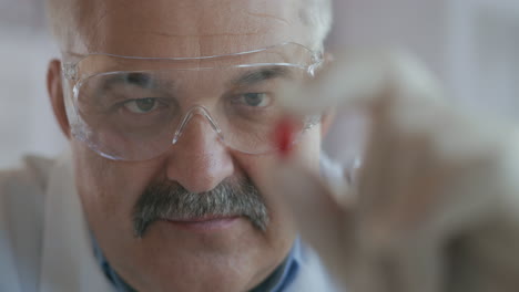 un científico masculino sostiene una píldora roja en sus manos y la mira de cerca en cámara lenta. imágenes de alta calidad 4k